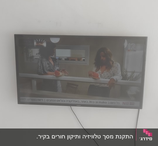 טלוויזיה תלויה על קיר עם כבל חשמל גלוי